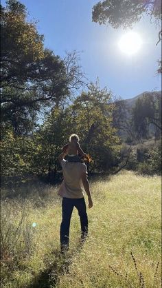 a man holding a baby in the middle of a field