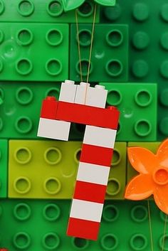 a lego christmas tree made out of green and red bricks with an ornament hanging from it