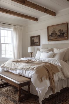 a bed with white linens and pillows in a bedroom next to a large window