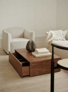 a living room with two chairs and a coffee table in the middle, on top of a hard wood floor