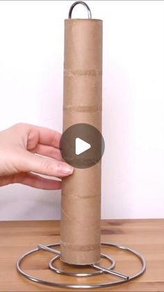 a person holding a roll of toilet paper on top of a metal holder with a video