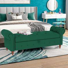 a bedroom with teal walls and furniture in the corner, along with a large bed