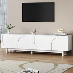 an entertainment center with a flat screen tv mounted on it's sideboard in a living room