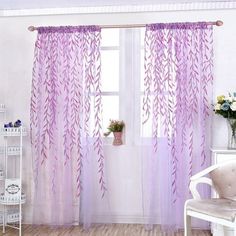 a living room with white furniture and purple curtains on the windowsills, along with a chair