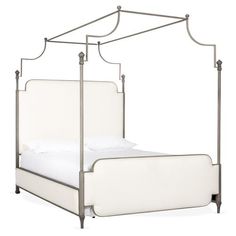 a white bed with an iron frame and headboard is shown in front of a white background