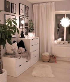 a living room filled with lots of furniture and pictures on the wall next to a window