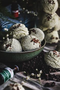 a bowl filled with cookies next to bottles of wine and chocolate chips on a table