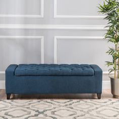 a blue bench sitting on top of a rug next to a potted plant