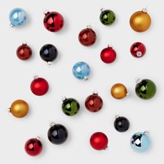 many different colored christmas ornaments on a white surface