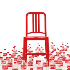 a red chair sitting on top of a pile of empty coke bottles in front of a white background