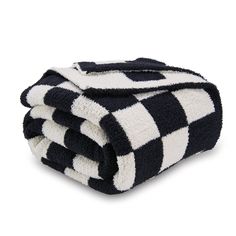 the black and white checkered blanket is folded up on top of each other,