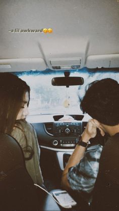 two people sitting in the back seat of a car