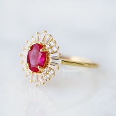 Beautiful Vintage Inspired Ruby Ring ►Base Metal: Sterling Silver (925) ►Plating: 14K Gold ►Accented With Simulated Diamonds ►Please be aware that plated jewelry can wear off over time, if this is a concern we would suggest going with the sterling silver or solid gold jewelry option. ►Style: Art-Deco Main Stone: Ruby Color: Red Gemstone Creation: 100% Genuine Lab-Grown Ruby Stone Shape: Oval Cut Gem size: 7.0 x 5.0 mm Carat Weight: 0.76 ct. (Approx.) ►Handling time: 1-2 business days ►Free domes Classic Ruby Halo Ring, Classic Ruby Ring With Halo Setting For Promise, Classic Halo Ruby Promise Ring, Classic Ruby Ring With Center Stone For Promise, Classic Ruby Ring With Halo Setting, Timeless 14k Gold Ruby Wedding Ring, Classic Ruby Ring With Halo Design For Promise, Timeless Ruby Rings For Wedding, Classic Ruby Ring With Halo Design