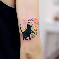 a black cat tattoo on the left arm and right arm with flowers, stars, and planets