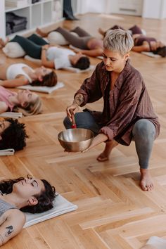 a group of people laying on the floor with one person holding a bowl in front of them