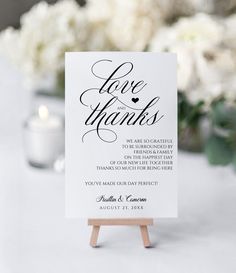 a white card with the words love and thanks on it sitting on top of a wooden easel