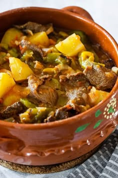 a brown bowl filled with food on top of a table