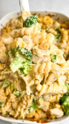 a white bowl filled with macaroni and cheese covered in broccoli florets