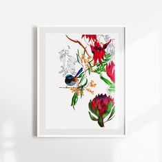 a white framed wall hanging on the side of a wall with flowers and leaves in it