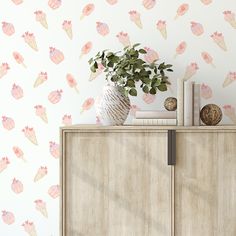 an ice cream themed wallpaper with pink and yellow cones on it, next to a wooden cabinet