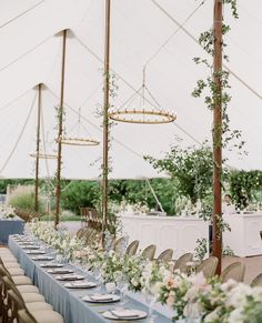 an outdoor tent with tables and chairs set up for a formal dinner or wedding reception