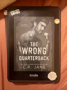 the wrong quaterback by c r jane is displayed on a bed with pink sheets