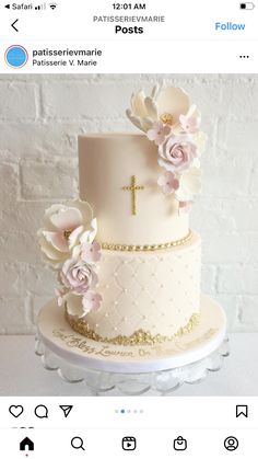 a three tiered white wedding cake with pink flowers on the top and gold trim