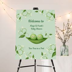 a welcome sign with two peas in a pea pod on the front and green background