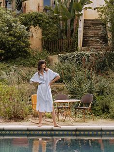 a woman standing next to a swimming pool