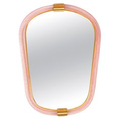 a pink and gold framed mirror on a white background with an oval border around it