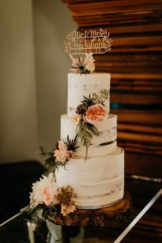 a three tiered cake with flowers on top