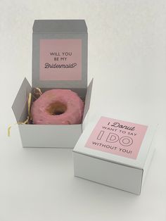 a pink donut in a box with a message on the front and back side