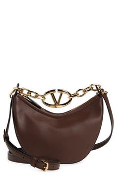 A gleaming chain centered with a VLOGO insignia spans the top of this hobo crafted from grained leather in a slouchy crescent silhouette. Top zip closure Chain top carry handle; removable, adjustable shoulder strap Leather Made in Italy Designer Handbags Brown Shoulder Bag With Metal Logo For Everyday, Chic Brown Bags With Metal Logo, Elegant Brown Shoulder Bag With Metal Logo, Luxury Brown Bag With Metal Logo, Luxury Hobo Shoulder Bag With Chain Strap, Luxury Brown Shoulder Bag With Metal Logo, Brown Leather Shoulder Bag With Chain Detail, Valentino Vsling Shoulder Bag, Valentino Crossbody