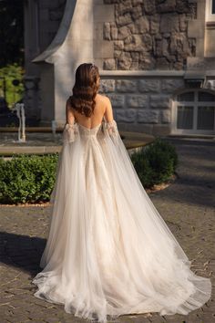 the back of a woman's wedding dress in front of a building