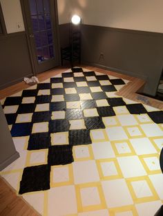 the floor is covered with black and white squares, which are painted yellow in an empty room