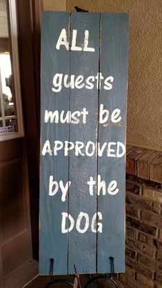 a wooden sign that says all guests must be approved by the dog on it's side