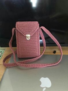 a pink purse sitting on top of a laptop computer