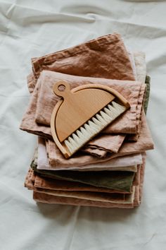 a pile of cloths with a wooden brush on top