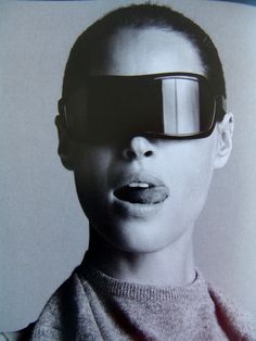 a woman with glasses on her face and tongue sticking out from behind the image is black and white