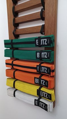 an assortment of martial belts hanging on a wall