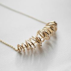 This hand formed gold wire necklace is truly one of a kind. Each one is free formed out of gold plated wire to be both delicate and sophisticated. This necklace can be made out of gold plated or sterling silver wire and chain. Approx I8" in length, Gold wire swirl approx. 1.5" long. 14k Gold Wire Wrapped Necklace, Minimalist Gold Spiral Jewelry, 14k Yellow Gold Wire Wrapped Necklace, Minimalist Yellow Gold Wire Wrapped Necklace, Gold Wire Wrapped Swirl Jewelry, Gold Swirl Wire Wrapped Jewelry, Unique Yellow Gold Wire Wrapped Necklaces, Sterling Silver Yellow Gold Wire Wrapped Necklaces, Unique Yellow Gold Wire Wrapped Necklace