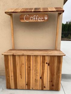 a wooden bench sitting on the side of a building next to a sign that says coffee