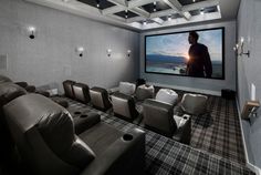 a man is watching a movie on the screen in an empty room with recliners