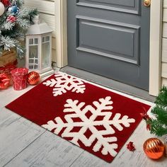 a red and white snowflake rug sitting on the front steps of a house