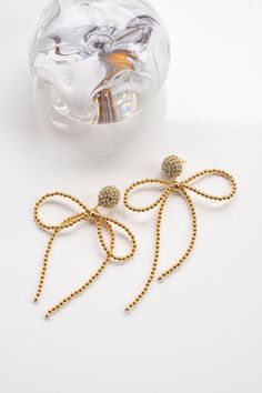 Interested in something a touch more unexpected? Lucia Earrings are a modern spin on a feminine classic—the bow. Tiny golden beads are strung tightly together and fashioned into a loose, flowing bow. In its center sits a statement bead, which hangs from a show-stopping rhinestone stud that bursts forth like a firework. You’ll have a hard time choosing from a handful of staple colors, but have no problem working Lucia Earrings into every occasion wear. She’s the perfect playful wink.24K Gold Plat Chic Jewelry With Butterfly Knot For Parties, Chic Party Jewelry With Butterfly Knot, Elegant Gold Beads Jewelry For Evening, Elegant Gold Beaded Jewelry For Parties, Elegant Gold Beaded Jewelry For Evening, Elegant Gold Jewelry With Butterfly Knot, Chic Evening Jewelry With Decorative Bow, Gold Plated Earrings With Gold Beads As A Gift, Elegant Earrings With Gold Beads