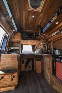 an interior view of a small camper with wood paneling and wooden flooring