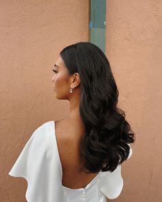 a woman with long black hair wearing a white dress