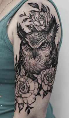 an owl and roses tattoo on the right arm, shoulder or upper arm with black ink