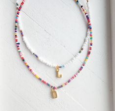 This adjustable seed bead initial necklace is a must have! Danity and cute it's the perfect summer accessory! Adjustable clasp makes it so anyone can wear it however you like! Rainbow bead necklace pattern may vary. How to order Choose a style of necklace Choose your initial Add to cart Adjustable White Charm Necklaces With Letter Beads, White Adjustable Charm Necklace With Letter Beads, Cute White Necklace With Letter Beads, Cute Summer Necklace With Letter Beads, Playful White Necklace With Letter Beads, Summer Beaded Necklace With Letter Beads As Gift, Cute Summer Beaded Necklaces With Letter Beads, Summer Gift Beaded Necklace With Letter Beads, Cute White Beaded Necklaces With Tiny Beads