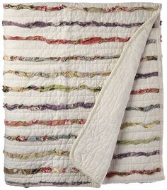 a white quilted blanket with multicolored stripes on the top and bottom half